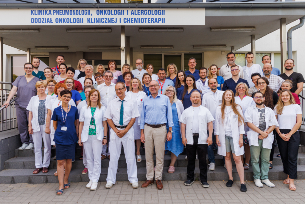 Zesp&oacute;ł Klinicznego Oddziału Pneumonologii, Alergologii, Onkologii Pulmonologicznej i Chor&oacute;b Wewnętrznych z Pododdziałem Wzmożonej Opieki Pulmonologicznej i Postcovidowej, Klinicznego Oddziału Rehabilitacji Pulmonologicznej i Pracowni Bronchoskopii Uniwersyteckiego Samodzielnego Szpitala Klinicznego Nr 4 w Lublinie stojący na schodach szpitala